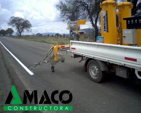 Camión con equipo de pintura de señalamiento horizontal aplicando la raya blanca de una carretera