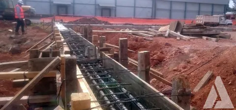 Cimbra y armado de trabes de cimentación para una nave industrial con trabajador supervisando
