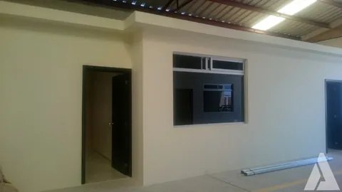 Oficinas de tablaroca con ventana y puertas construidas en el interior de una nave industrial
