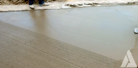 Superficie de pavimento de concreto fresco con texturizado rayado para antiderrapante