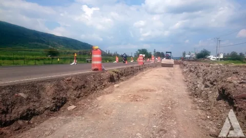 Terracerías de la ampliación de una carretera delimitadas con trafitambos naranjas