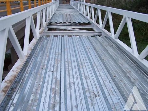 Tablero de lámina acanalada losacero sobre la armadura metálica blanca de un puente peatonal
