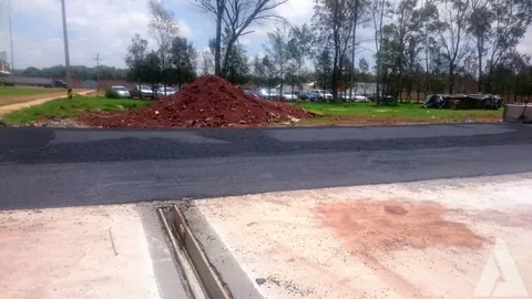 Dren pluvial lineal con rejilla embebido entre losa de concreto y carpeta asfáltica nueva